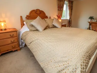 a bedroom with a large bed with a wooden headboard at Linwood in Thornton