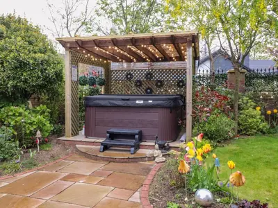 a fire pit in a garden with a pergola at Linwood in Thornton