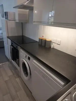 a kitchen with a stove and a washing machine at Sea Breeze Studio @ The Coach House in Saint Annes on the Sea