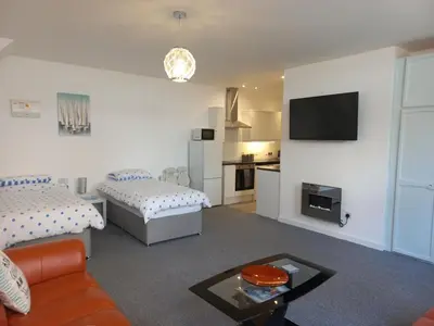 a living room with two beds and a tv at Sea Breeze Studio @ The Coach House in Saint Annes on the Sea