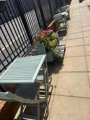 a table and chairs sitting on a sidewalk with flowers at For Students Only Apollo Court in Liverpool in Liverpool
