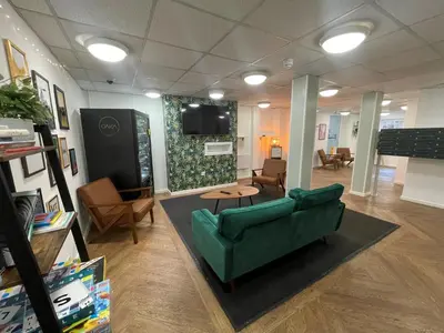 a living room with a green couch and a tv at For Students Only Apollo Court in Liverpool in Liverpool