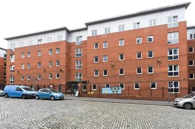 a brick building with cars parked in front of it at For Students Only Apollo Court in Liverpool in Liverpool