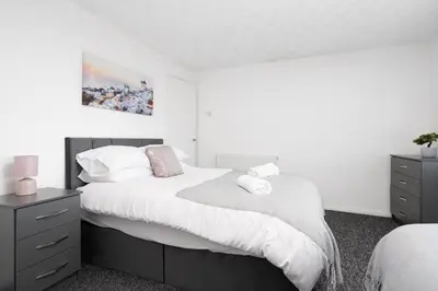 a bedroom with a large bed with white sheets and pillows at Large 3 bedroom Liverpool Free parking in Liverpool