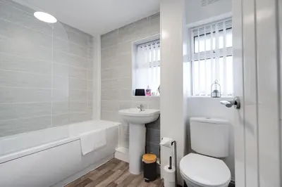 a white bathroom with a toilet and a sink at Large 3 bedroom Liverpool Free parking in Liverpool
