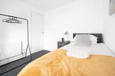 a bedroom with a bed with a yellow blanket at Large 3 bedroom Liverpool Free parking in Liverpool
