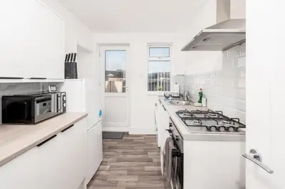 a white kitchen with a stove and a microwave at Large 3 bedroom Liverpool Free parking in Liverpool