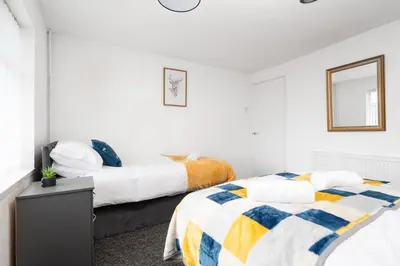 a bedroom with two beds and a mirror at Large 3 bedroom Liverpool Free parking in Liverpool