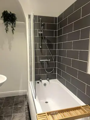 a bathroom with a shower and a bath tub at No. 10 - Home away from Home in Litherland