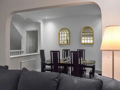 a living room with a couch and a dining room table at West Street House in Southport