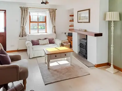 a living room with a white couch and a table at Hill View Cottage in Galgate