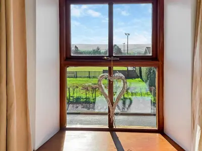 a heart carved into a window with a view at Hill View Cottage in Galgate