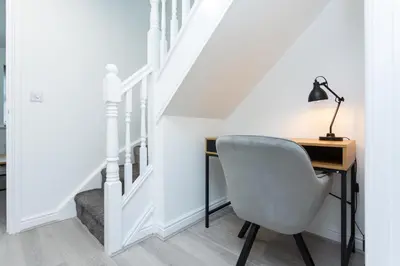 a desk with a lamp and a chair next to a staircase at Lancers Close House in Leyland