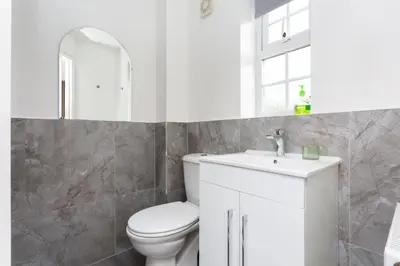 a white bathroom with a toilet and a sink at Lancers Close House in Leyland