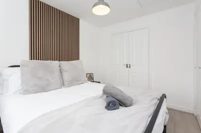 a bedroom with a white bed with a stuffed animal on it at Lancers Close House in Leyland