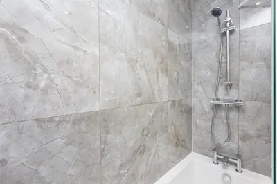 a bathroom with a shower with a white tub at Lancers Close House in Leyland