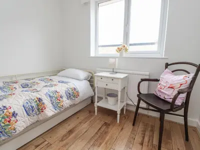 a bedroom with a bed and a chair and a desk at 14 Berwick Road in Lytham St Annes