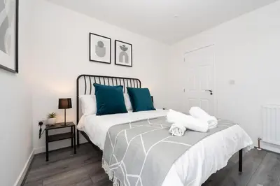 a white bedroom with a bed with blue pillows at Perfect Modern 4 bedroom in Liverpool in Liverpool