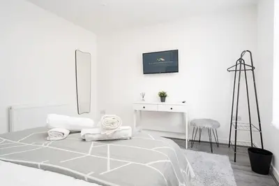 a white bedroom with a bed and a desk at Perfect Modern 4 bedroom in Liverpool in Liverpool
