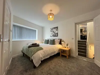 a bedroom with a large bed and a table at Eden Corner - 2 Bed in Morecambe