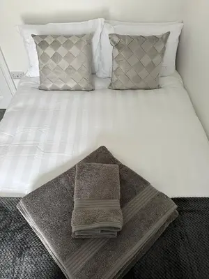 a bed with a tray with two towels on it at Eden Corner - 2 Bed in Morecambe