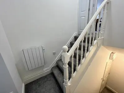 a staircase with a white radiator in a house at Eden Corner - 2 Bed in Morecambe