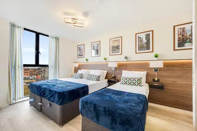 a hotel room with two beds and a window at Stunning 2 Bed Apartment U6 - Sleeps 8 in Liverpool