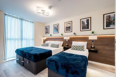 a hotel room with two beds and a window at Stunning 2 Bed Apartment U6 - Sleeps 8 in Liverpool
