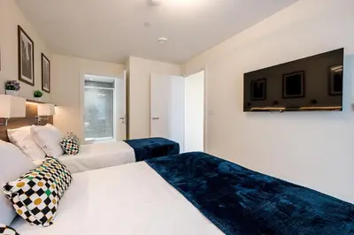 a bedroom with two beds and a flat screen tv at Stunning 2 Bed Apartment U6 - Sleeps 8 in Liverpool