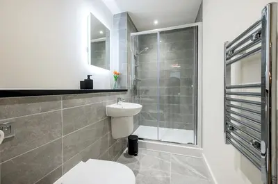 a bathroom with a toilet and a glass shower at Stunning 2 Bed Apartment U6 - Sleeps 8 in Liverpool