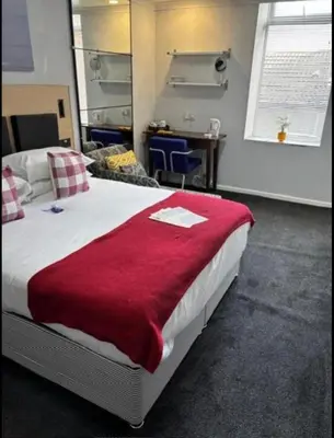 a bedroom with a large bed with a red blanket at Selwyn Stays in Liverpool