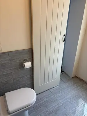 a bathroom with a white toilet and a door at Selwyn Stays in Liverpool