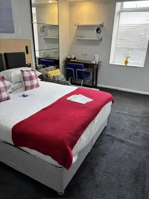 a bedroom with a large bed with a red blanket at Selwyn Stays in Liverpool
