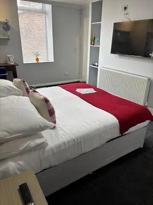 a bedroom with a bed with a red blanket on it at Selwyn Stays in Liverpool