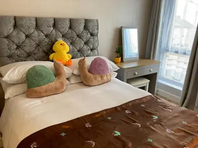 a bed with two stuffed ducks sitting on it at Selwyn Stays in Liverpool