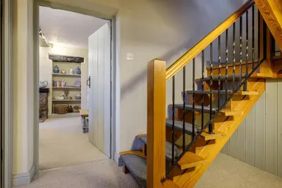 a wooden staircase in a home with a hallway at Sunny Brae in Grange Over Sands