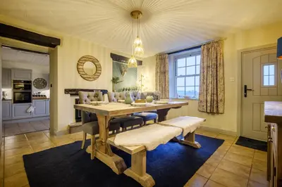a dining room with a wooden table and chairs at Sunny Brae in Grange Over Sands