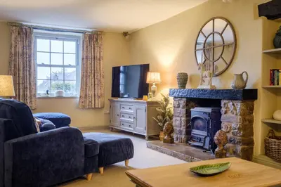 a living room with a fireplace and a television at Sunny Brae in Grange Over Sands