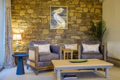 a living room with two chairs and a table at Sunny Brae in Grange Over Sands