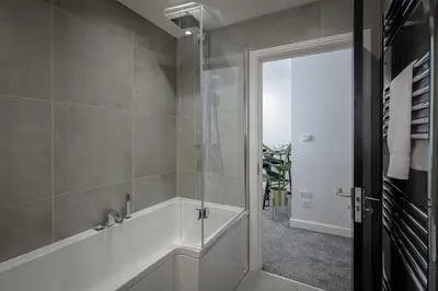 a bathroom with a tub and a glass shower at The 1878 by STAMP SA in Blackpool