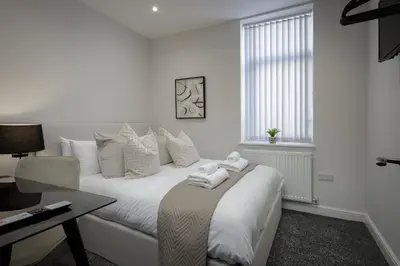 a white bedroom with a bed with towels on it at The 1878 by STAMP SA in Blackpool
