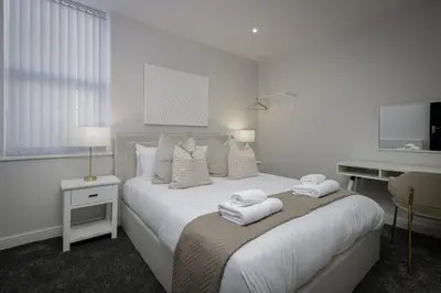 a white bedroom with a bed with towels on it at The 1878 by STAMP SA in Blackpool