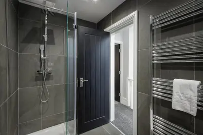 a bathroom with a shower and a glass door at The 1878 by STAMP SA in Blackpool