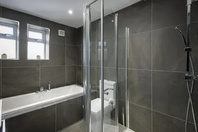 a bathroom with a shower and a tub and a toilet at The 1878 by STAMP SA in Blackpool