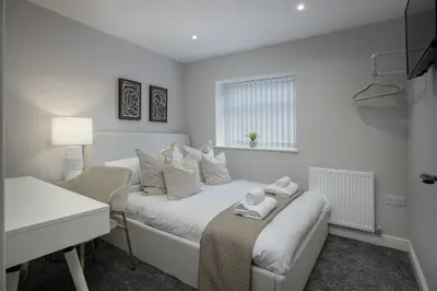 a white bedroom with two beds and a window at The 1878 by STAMP SA in Blackpool