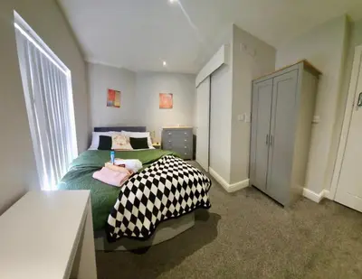 a bedroom with a green bed with black and white sheets at Beautiful Double Bedroom in Liverpool