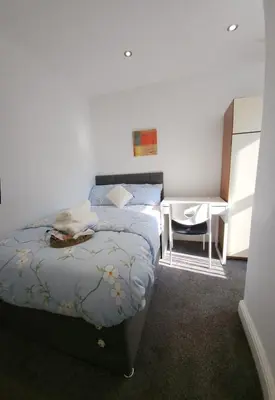 a bedroom with a bed and a desk and a table at Beautiful Double Bedroom in Liverpool