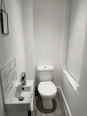 a white bathroom with a toilet and a sink at Beautiful Double Bedroom in Liverpool