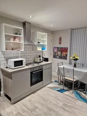 a kitchen with a stove and a table in it at Beautiful Double Bedroom in Liverpool