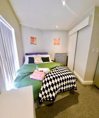 a bedroom with a bed with a checkered blanket at Beautiful Double Bedroom in Liverpool